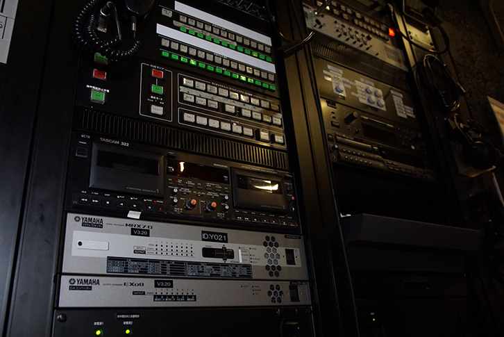 大ホールの舞台袖（下手）
ヤマハ「MRX7-D」が設置されている　右隣のラックの上の操作しやすい場所にコントローラーが設置されている