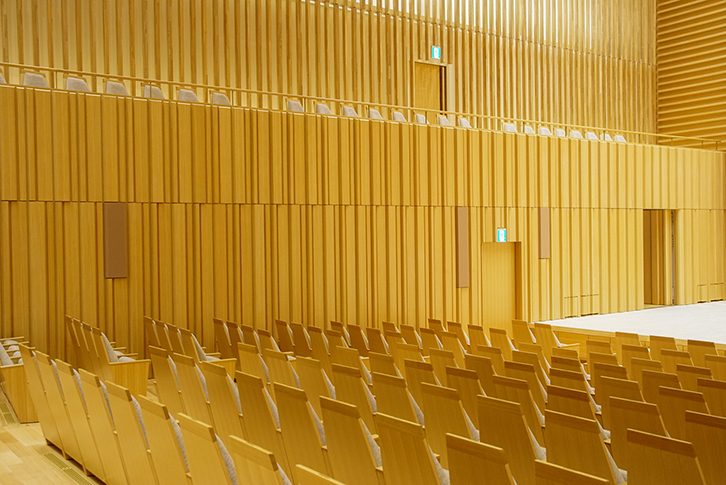 濃い色の長方形のサランネットの部分に壁面スピーカーが埋め込まれている。ステージ寄りはね返り用、中央がメインスピーカー、左端が補助スピーカー