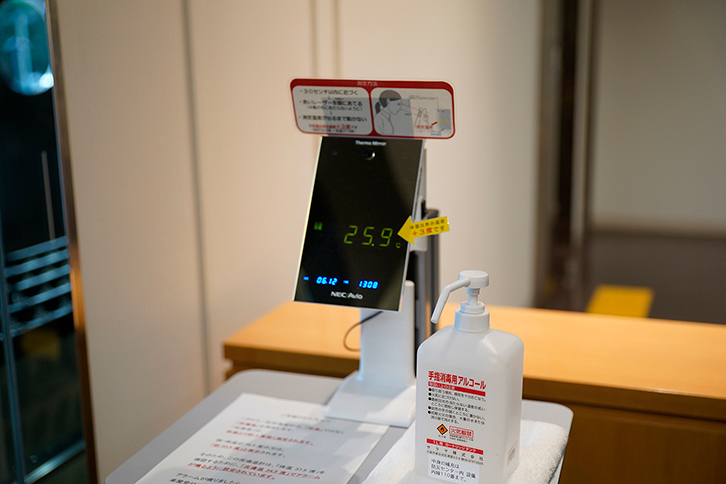 楽屋入り口の受付にはアクリル板の他、非接触型の体温計、手指消毒用アルコールなどが設置されている