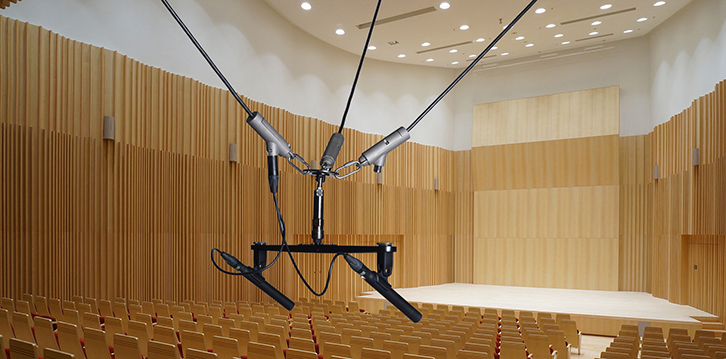 イーサーネット・ケーブル接続に対応した電動つりマイク装置、HYFAX MHN１。ホールでは観客の頭上に設置されるシステムのため、滑車にモーターを搭載することで錘（おもり）を廃し、安全性を確保している。マイクは別売りで、会場に合った任意のものを使用可能