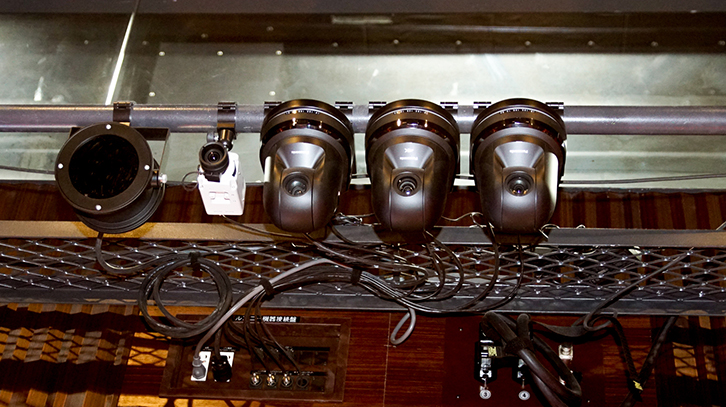 2階席先端に用途に応じて設置された4台のカメラ　　
左より赤外線ライト（暗視用）、4Kカメラ（ホワイエのお客様用）、　暗視カメラ（暗転時用）、
リモート操作可能なカメラ（舞台監督用）、定点カメラ（スタッフ用）
