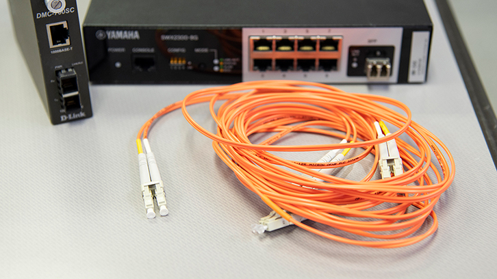 手前のオレンジのケーブル「光ファイバーケーブル」